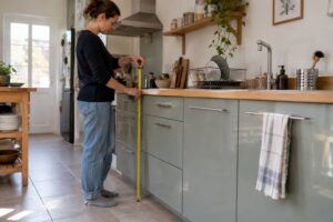 Une femme qui mesure la hauteur d'un plan de travail